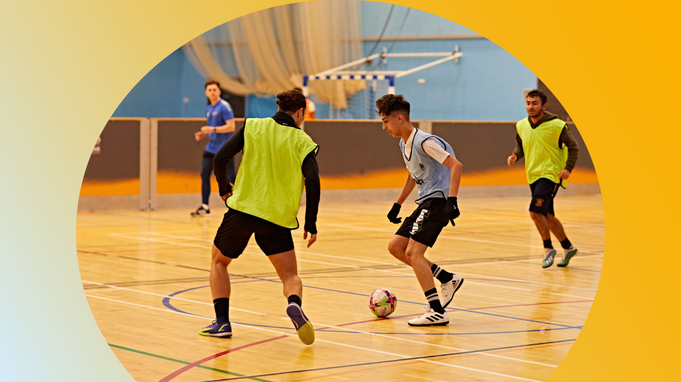 Three students playing futsal