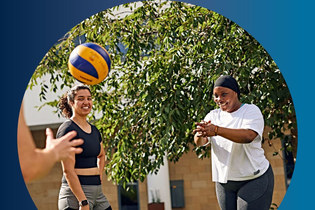 Students playing with volleyball outdoors